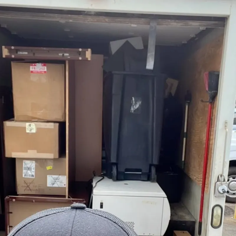 The box truck packed wall to wall with boxes, cabinets and furniture.