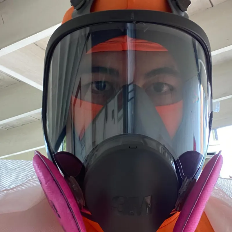 An Unko's crew member wearing a full-face orange respirator on a heavy clean-out job.
